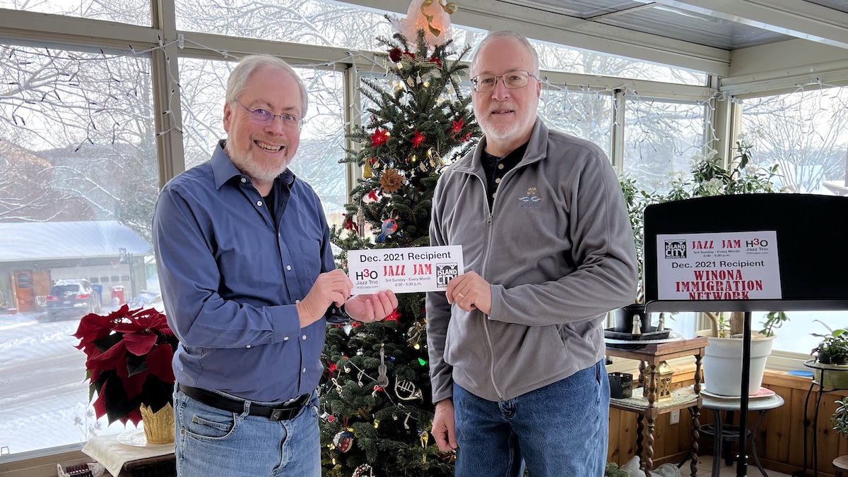 Pastor Michael Short (Central Lutheran Church) receives donations for the Winona Immigration Network from H3O’s Eric Heukeshoven.