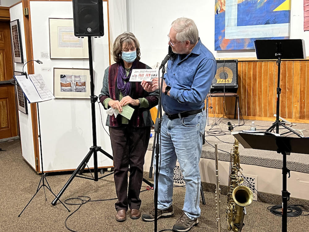 Debi Niebuhr (left) accepts a check from Eric Heukeshoven (right) in the amount of $675 from the proceeds of the Jazz Jam session held at Island City Brewing Company.