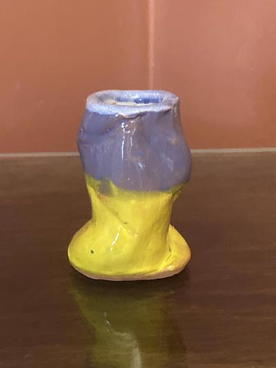 Photo of a purple and yellow pinch pot by Richard Spiller.