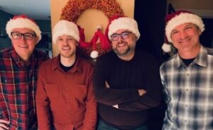 Photo of the members of Johnson Street Underground wearing Santa hats.