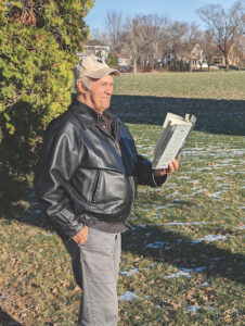 Photo of Orval Lund reading a book outdoors.