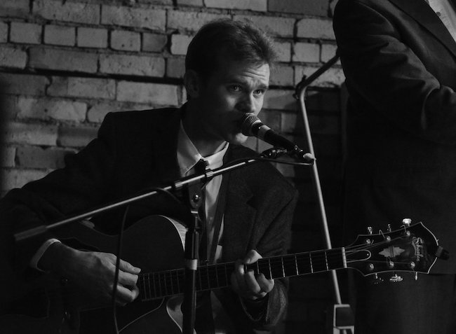 Photo of musician Sam Miltich performing on guitar.