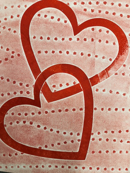 Photo of a monoprinted Valentine with two red heart outlines.