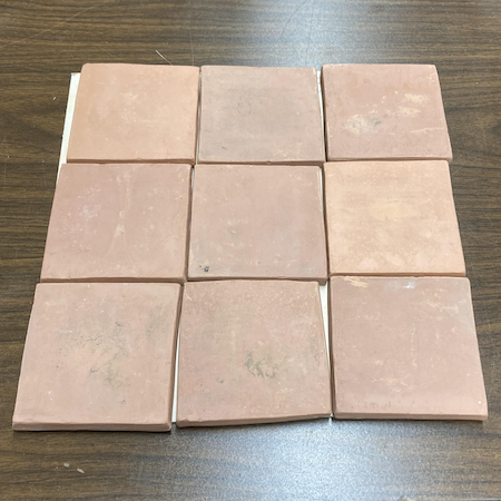 Photo of nine earthenware pottery tiles arranged in a square.