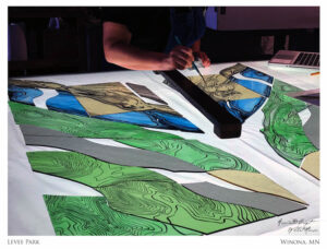 An artist at Associated Crafts & Willet Hauser working on the stained glass that was installed in the Levee Park entrance sign.