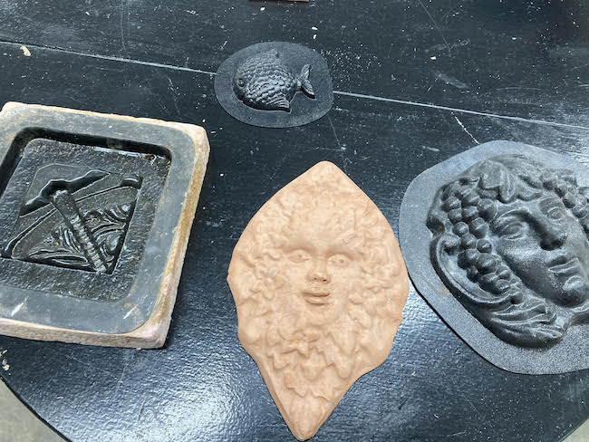 Photo of a ceramic molded face and several other plastic molds.