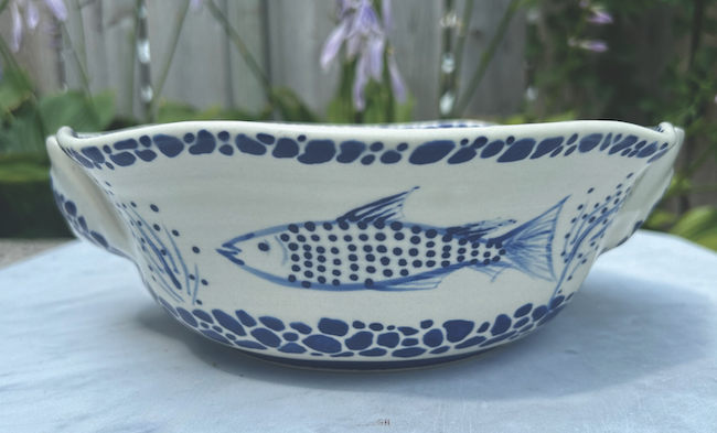 Blue and white ceramic bowl painted with a fish, by Teresa Schumaker.