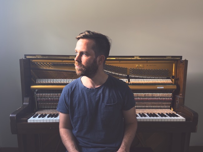 Photo of Philip Daniel seated in front of a piano.