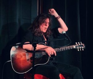 Photo of Claude Bourbon performing with guitar.