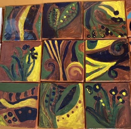 Photo of nine colorfully decorated ceramic tiles.