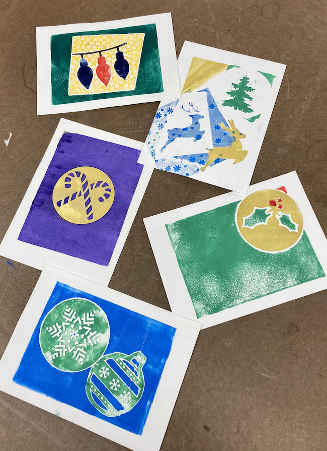 Photo of several colorful, holiday-themed monoprints.