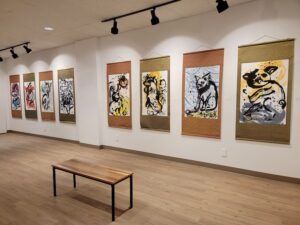 Photograph of eight large watercolor artworks by Nancy XiáoRong Valentine exhibited on a gallery wall.