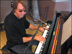 Photo on John McAndrew playing a keyboard.