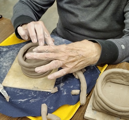 Photo of hands making a coiled pot.