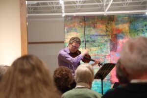 Photo of Erik Rohde performing on violin at the Minnesota Marine Art Museum.
