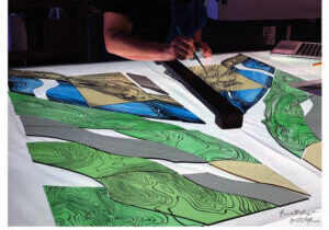 An artist at Associated Crafts & Willet Hauser working on the stained glass that was installed in the Levee Park entrance sign.