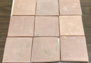 Photo of nine earthenware pottery tiles arranged in a square.