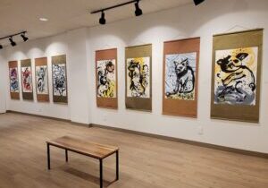 Photograph of eight large watercolor artworks by Nancy XiáoRong Valentine exhibited on a gallery wall.