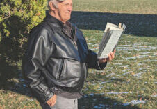 Photo of Orval Lund reading a book outdoors.