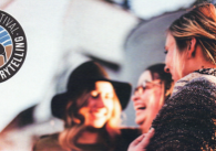 Photo showing three women smiling, outdoors, along with Sandbar Storytelling Festival's logo.