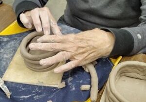 Photo of hands making a coiled pot.