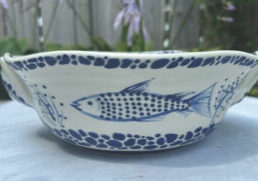 Blue and white ceramic bowl painted with a fish, by Teresa Schumaker.