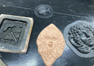 Photo of a ceramic molded face and several other plastic molds.