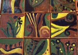 Photo of nine colorfully decorated ceramic tiles.