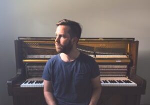 Photo of Philip Daniel seated in front of a piano.