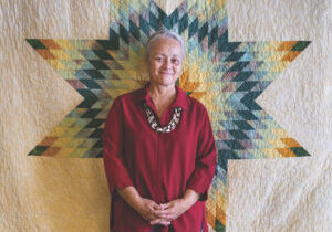 Photo of Gwen Westerman with a quilt.